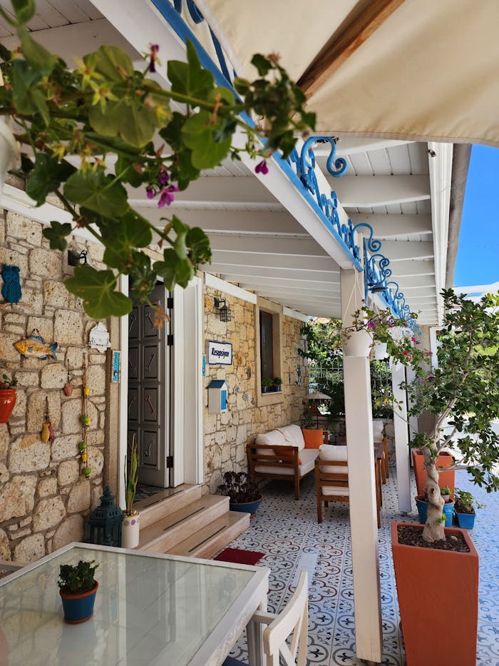 Services Cozy stone patio in Alaçatı with vibrant decor and blooming plants.